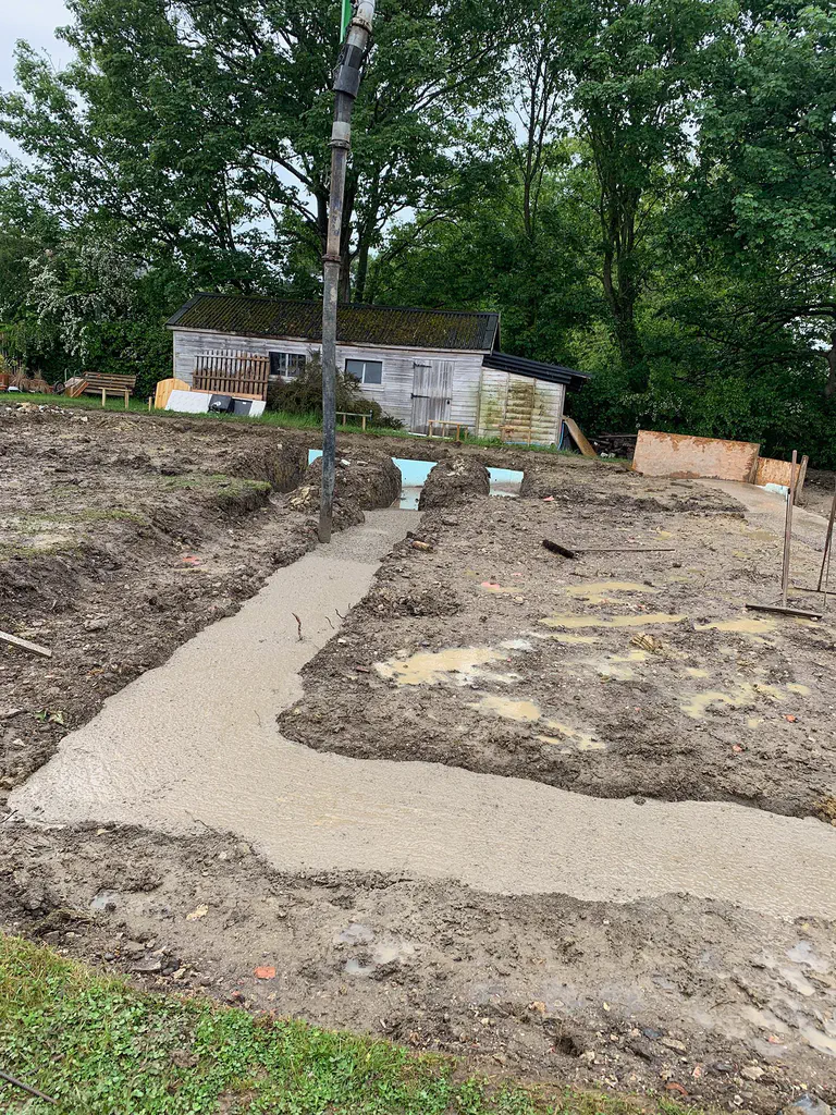 A poured concrete base on a cleared plot