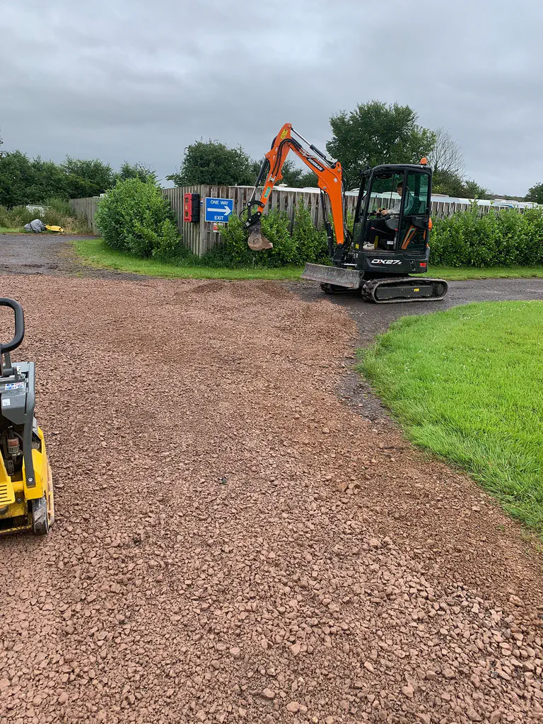 A reinstated stone driveway with an excavator and roller on site