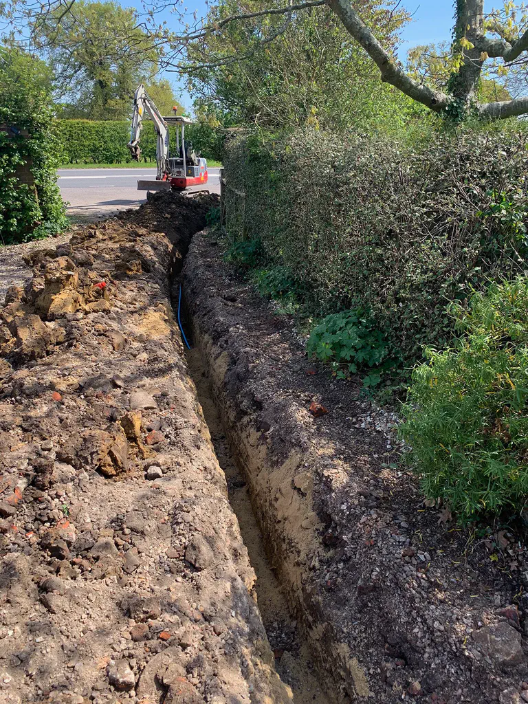 A long service trench excavated along a hedgerow
